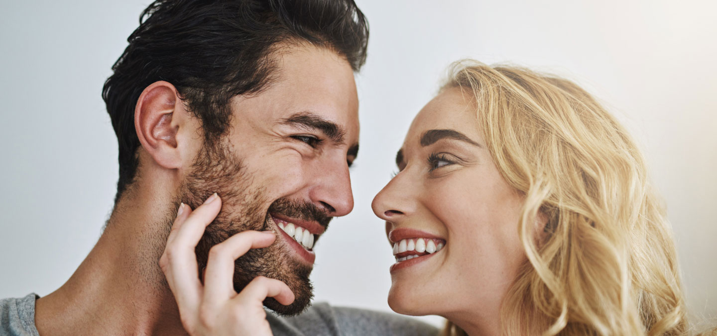 couple with thick hair looking into each others eyes